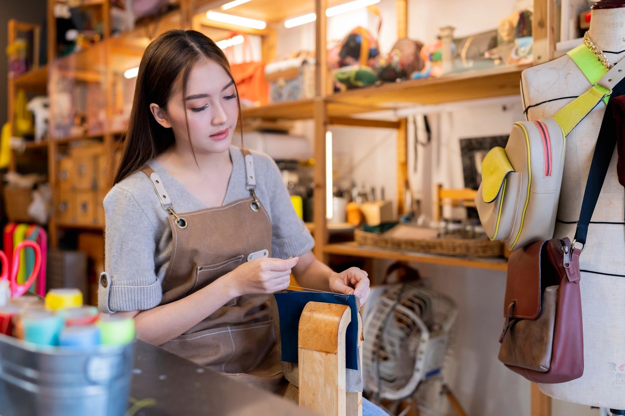 Artisan working with leather by hand at a workshop table